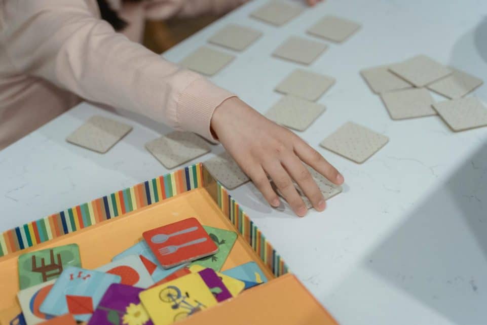 A child engages in a fun memory matching card game, showcasing focus and concentration.