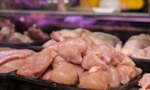 Fresh raw chicken breasts displayed in a supermarket setting, ready for purchase.