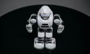 A detailed view of a white robot toy standing on a black surface, showcasing modern toy technology.