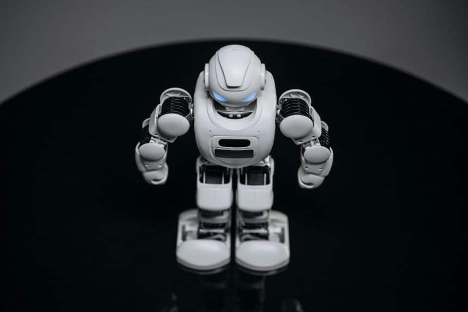 A detailed view of a white robot toy standing on a black surface, showcasing modern toy technology.