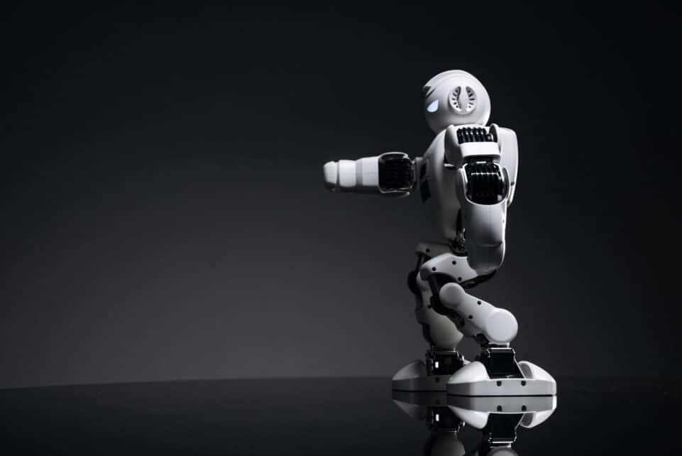 A white robot showcasing modern design on a sleek dark surface.
