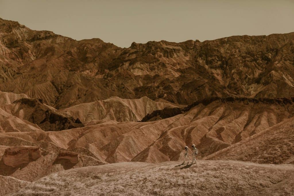 Astronauts exploring a stunning desert landscape, resembling Mars.
