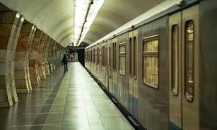 A Moscow subway station with a train on the empty platform, highlighting architectural details.