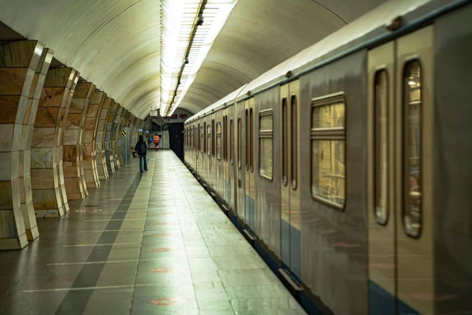 A Moscow subway station with a train on the empty platform, highlighting architectural details.