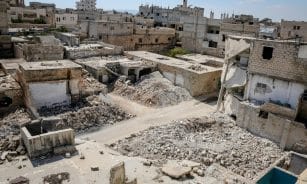 Aerial view of war-torn buildings and rubble in Idlib, Syria, highlighting urban destruction.