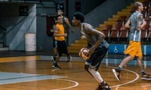 Young athletes engage in a dynamic basketball practice indoors, focused on skill development.