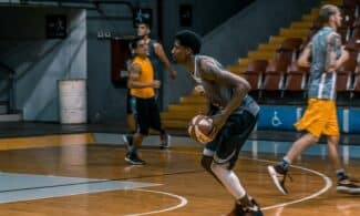 Young athletes engage in a dynamic basketball practice indoors, focused on skill development.