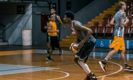 Young athletes engage in a dynamic basketball practice indoors, focused on skill development.