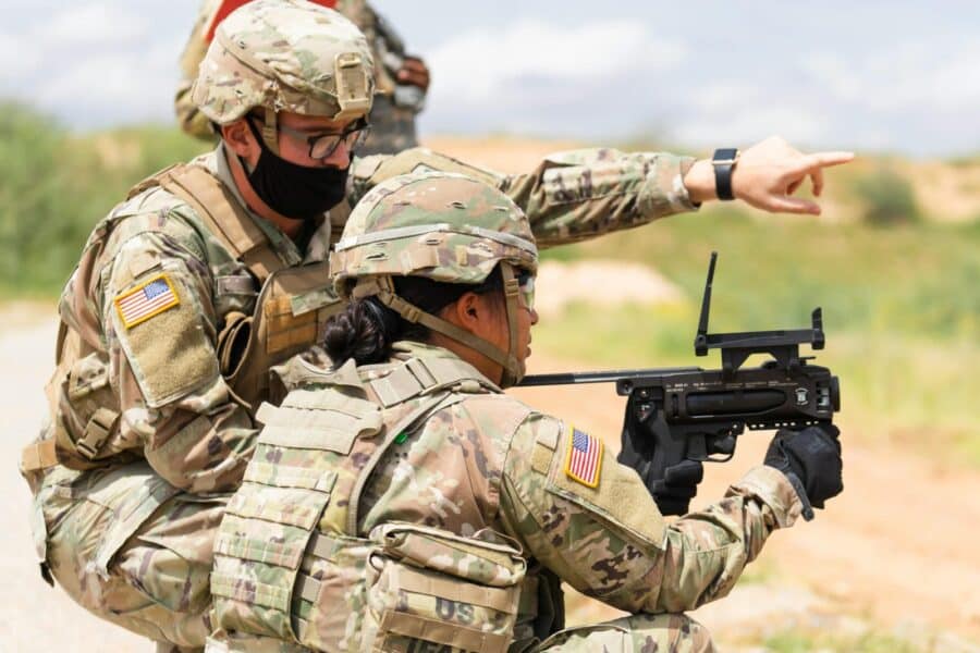 Two US soldiers engage in outdoor combat training, focusing on weapon proficiency.