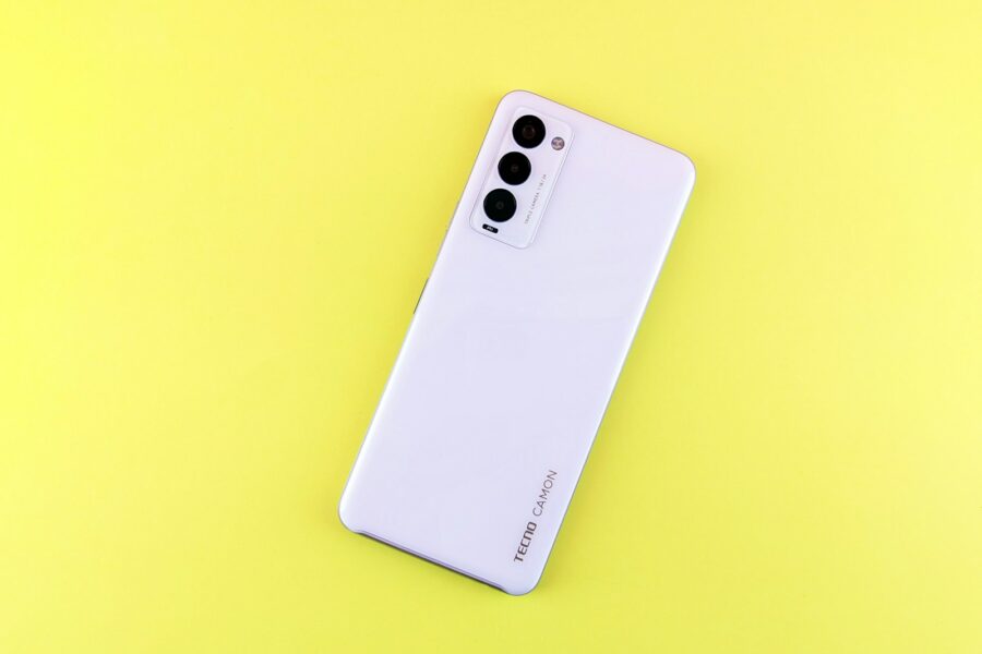 a white cell phone sitting on top of a yellow surface