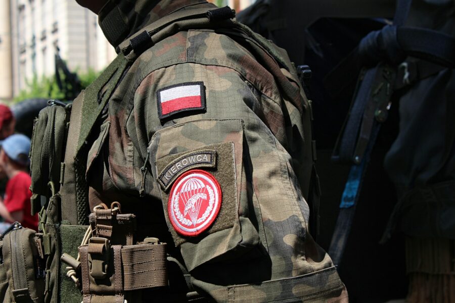 a man wearing a camouflage jacket with a flag on it