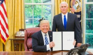 2 men in black suit sitting on red chair