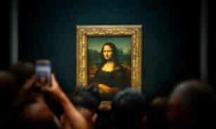 A group of people taking pictures of a painting