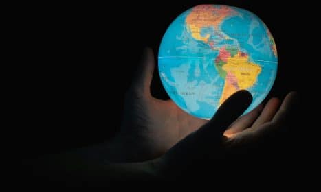 blue and brown globe on persons hand