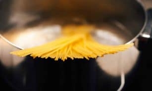 a close up of a metal pot with noodles in it