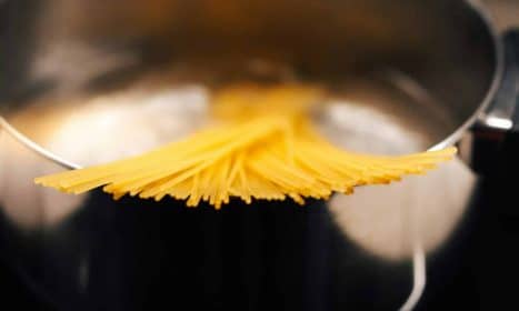 a close up of a metal pot with noodles in it
