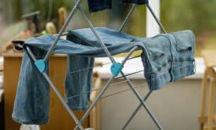 An ironing board with clothes on it in front of a window