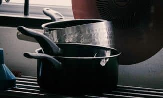 Stack of pots and pans on a drying rack.