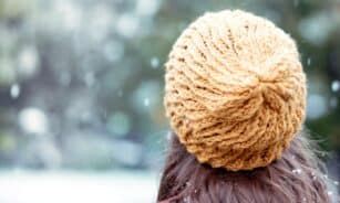 woman in brown knit cap and red shirt