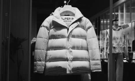 a white puffer jacket hanging in a store window