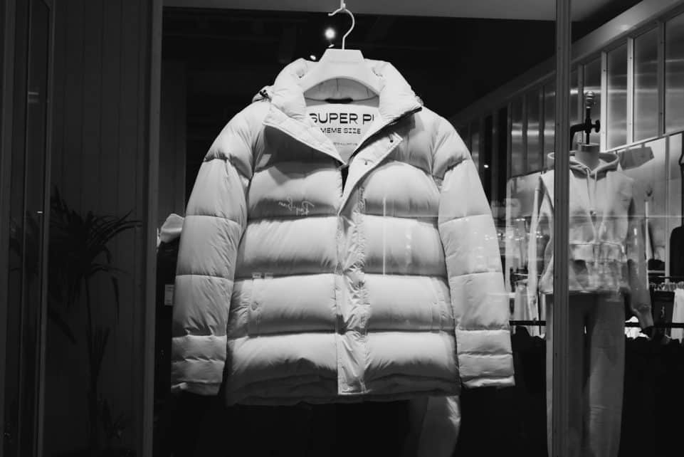 a white puffer jacket hanging in a store window
