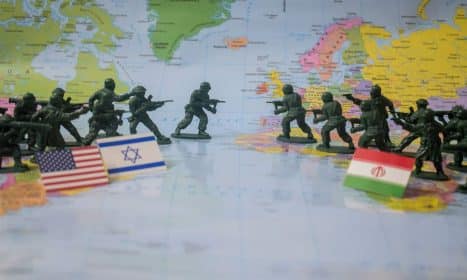 Toy soldiers face off on world map with flags.