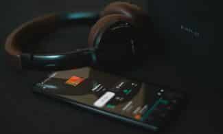 black and white remote control beside black headphones