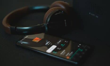 black and white remote control beside black headphones