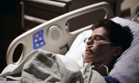 man in blue hoodie wearing eyeglasses