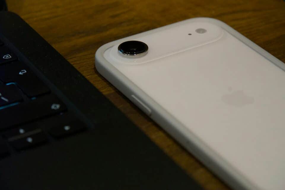 White iPhone with clear case next to laptop