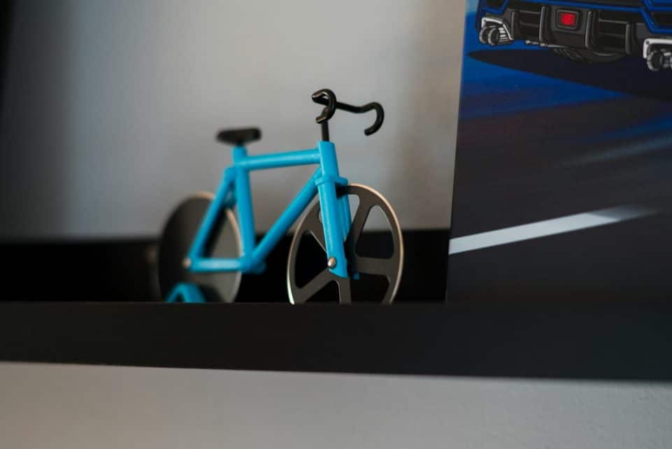 a blue bike sitting on top of a shelf