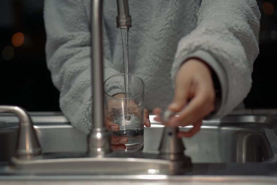 person holding clear glass container