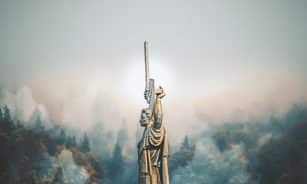 person standing on cliff painting