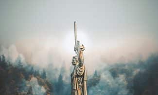 person standing on cliff painting