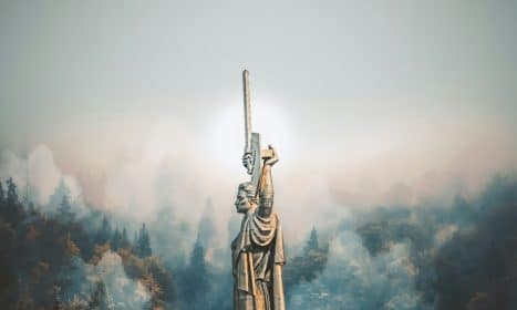 person standing on cliff painting