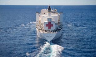 A large white hospital ship sails on the ocean