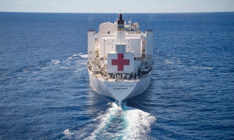 A large white hospital ship sails on the ocean