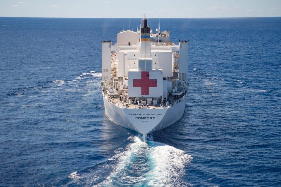 A large white hospital ship sails on the ocean