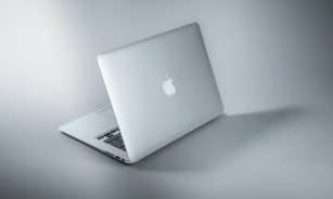 silver macbook on white table