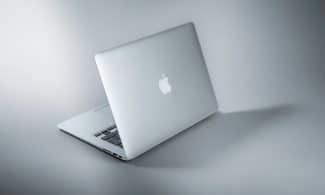 silver macbook on white table