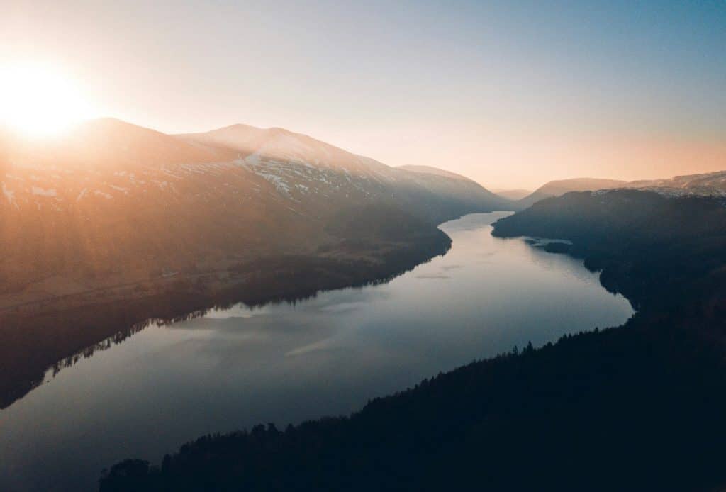 lake between trees and mountains