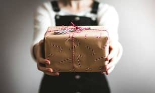 person showing brown gift box