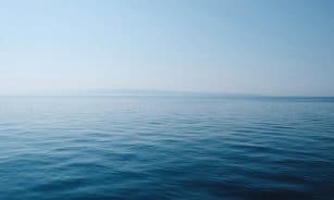 body of water under blue and white sky at daytime