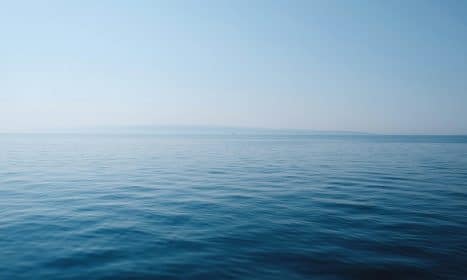 body of water under blue and white sky at daytime
