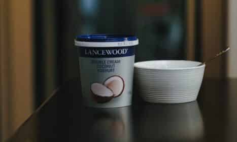 a cup of coffee next to a container of ice cream