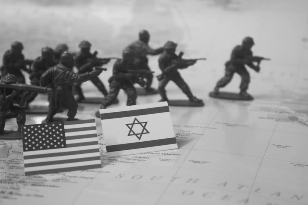 Toy soldiers stand near american and israeli flags.