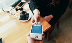 person holding credit card swipe machine