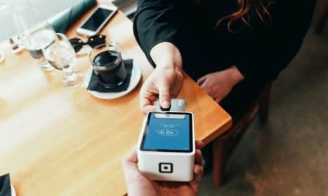 person holding credit card swipe machine