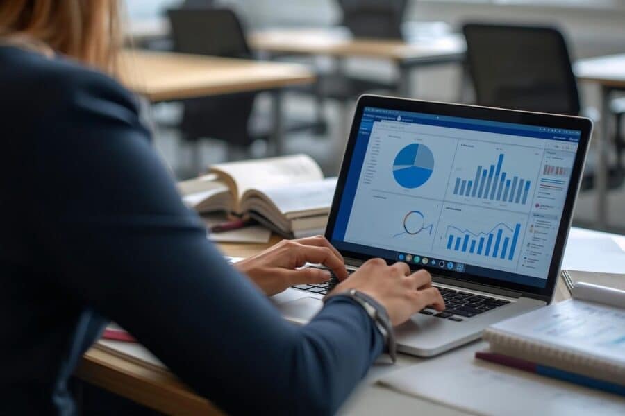 Woman working on laptop with charts and graphs.