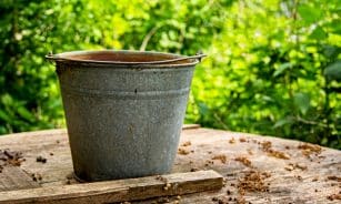 gray steel bucket on brown wooden table